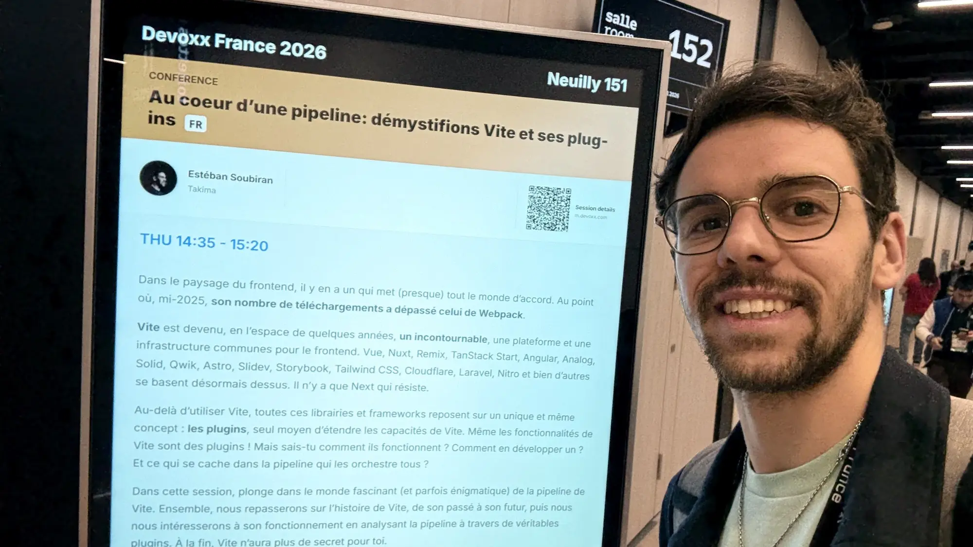 Estéban devant le panneau d'annonce, avant le début du talk